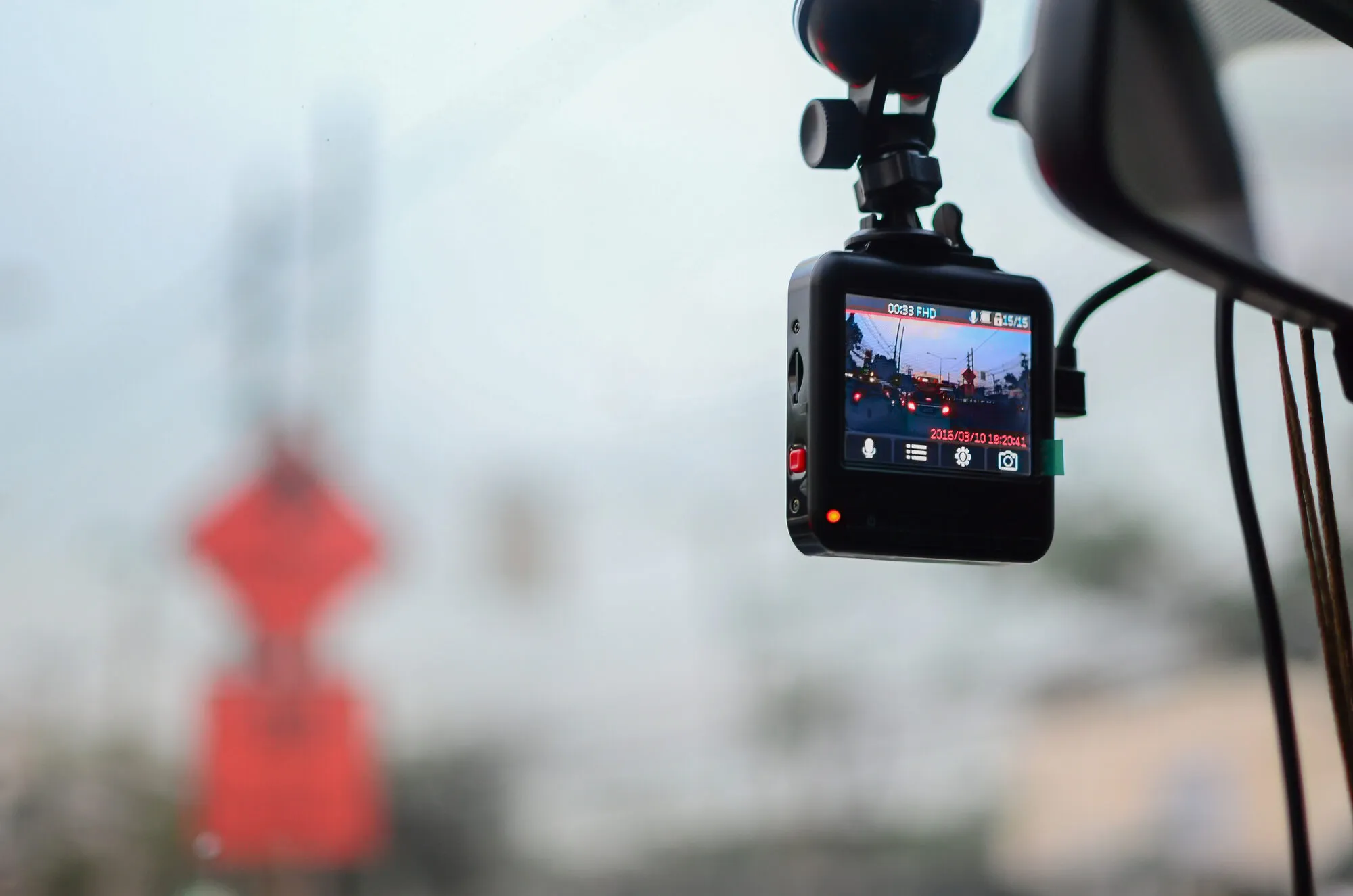 A road-facing dashcam recording the road ahead at dusk from inside a vehicle
