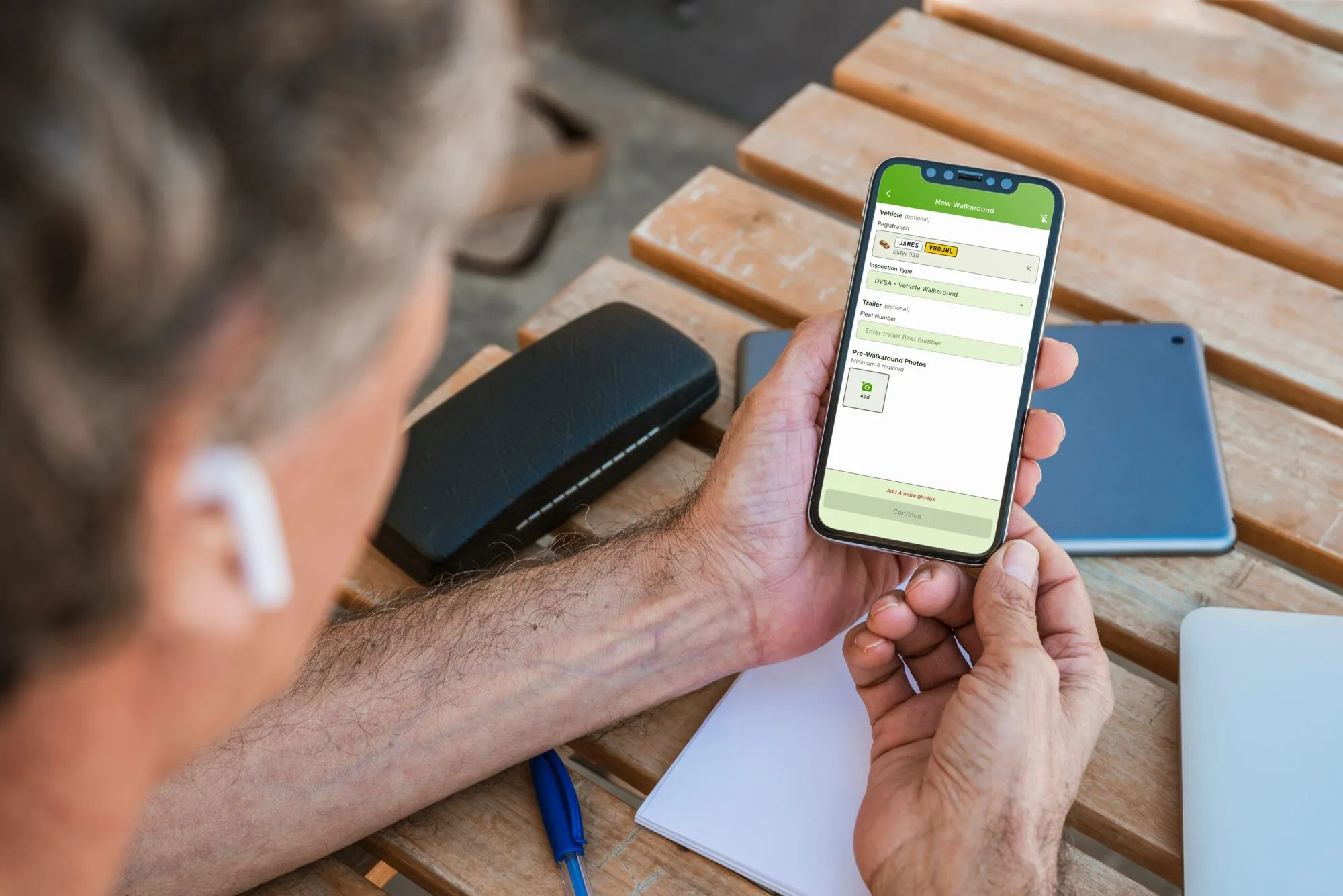 A driver starting a new walkaround inspection on the OnPoint app outside the vehicle